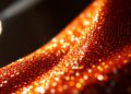 An extreme close-up photograph of shimmering, high-contrast sequins in a dramatic, high-fashion studio lighting setup, conceptually representing the glitz and glamour of celebrity culture.