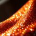 An extreme close-up photograph of shimmering, high-contrast sequins in a dramatic, high-fashion studio lighting setup, conceptually representing the glitz and glamour of celebrity culture.