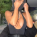 Person covering their face with a hoodie in a nightlife setting.