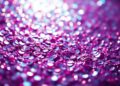 An abstract close-up photograph of shimmering, glittering textures in high contrast lighting, conceptually representing the glamour and star power of Laufey's 'Madwoman' music video.