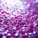 An abstract close-up photograph of shimmering, glittering textures in high contrast lighting, conceptually representing the glamour and star power of Laufey's 'Madwoman' music video.