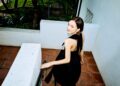 Maude Apatow descending a staircase in a black dress.