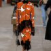 Fashion model showcasing a vibrant outfit on a runway.