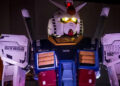 Two women look out from a restaurant window at Gundam.