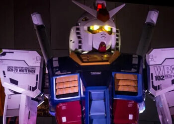 Two women look out from a restaurant window at Gundam.