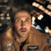 A man in a spacecraft wearing a detailed flight suit looks intensely at a screen, suggesting a scene from a space-themed film or TV show