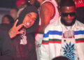 Pooh Shiesty and Gucci Mane at a club, one in a black hoodie making a gesture, the other in sunglasses and a colorful jacket with jewelry. Pooh was signed to Gucci Mane's label, 1017. The DOJ is alleging that Pooh kidnapped Gucci and forced him to sign papers releasing him.