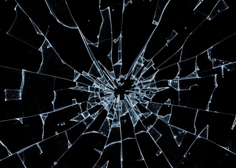 An extreme close-up of a shattered glass surface, reflecting the fragility and complexity of the British royal family's public image and the scandals that have plagued Prince Andrew.