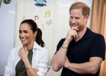 Harry and Meghan laughing during a visit to a refugee camp in northern Jordan in February