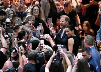 Britain's Prince Harry (C), Duke of Sussex, and his wife Meghan, the Duchess of Sussex, meet people at the Royal Children's Hospital in Melbourne on April 14, 2026.