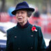Princess Anne wears a green coat with a red poppy
