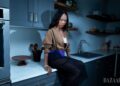 Individual seated in a modern kitchen.