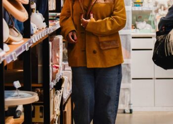 Individual browsing shelves in a store filled with various products.