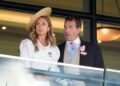 Harriet Sperling and Peter Phillips during day one of Royal Ascot at Ascot Racecourse, Berkshire. She is wearing a white jacket with puffed sleeves and a straw hat which sits at an angle on her long, blonde hair. He is wearing a dark-coloured jacket, a light grey waistcoat, a pink shirt with a white collar and a light blue tie.