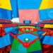 A cubist-style painting featuring overlapping geometric shapes and planes of bright blue, red, and yellow, conceptually representing the disruption and fragmentation caused by a last-minute lineup change in a baseball game.