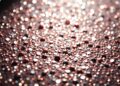 An extreme close-up of shimmering, glittering sequins in dramatic, high-contrast studio lighting, conceptually representing the glamour and pressures of Hollywood celebrity culture.