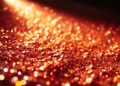 An abstract, high-contrast close-up photograph of shimmering, glittering sequins, capturing the glamour and energy of the music industry.