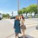 Two women posing for a photo outside the Washington Monument on a sunny day