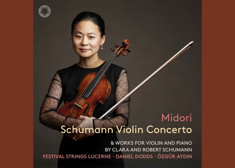 A woman in black holds a violin and bow against a gray background. Text reads: Midori Schumann Violin Concerto with details about the recording and performers.
