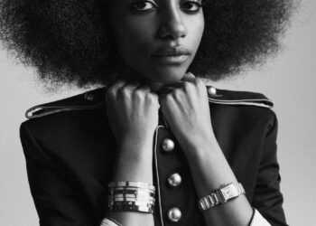 A person with an afro hairstyle wearing a military-style jacket.