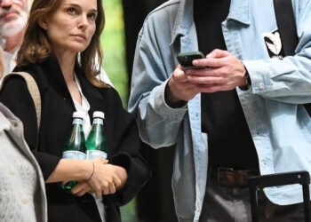 Natalie Portman announced she and Tanguy Destable (seen above looking at his phone while standing alongside Portman) are expecting a baby on April 17, 2026. BACKGRID