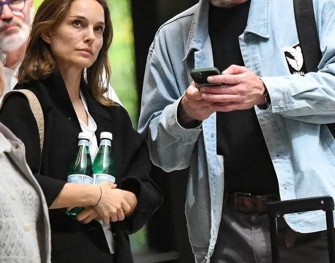 Natalie Portman announced she and Tanguy Destable (seen above looking at his phone while standing alongside Portman) are expecting a baby on April 17, 2026. BACKGRID