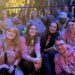 A group of people smile at the camera, many wearing sweatshirts that read "Casa Bonita United."