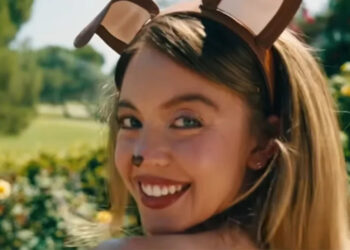 A close up of Sydney Sweeney wearing dog ears and smiling in Euphoria.