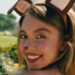 A close up of Sydney Sweeney wearing dog ears and smiling in Euphoria.