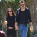 a couple walking handinhand while holding iced coffee drinks