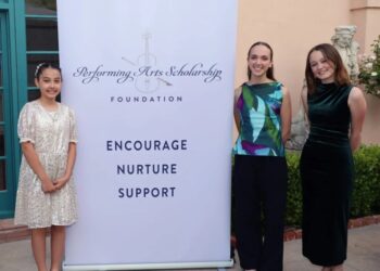 1st place winners stand for a photo next to a Performing Arts Scholarship Foundation sign. They are Chloe Emma Silva, left, Lydia Plaut, Nikki Seppala Kurnik. (Monie photograph)