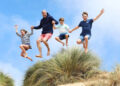 Prince William jumping with George, Charlotte and Louis on Norfolk beach