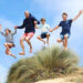 Prince William jumping with George, Charlotte and Louis on Norfolk beach
