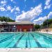 An outdoor pool under a bright blue sky.