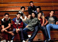 Group of young adults casually seated on bleachers, each displaying a distinct relaxed fashion style