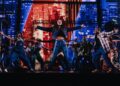 A woman sings onstage in a musical.
