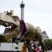 People take part in a march organised by the anti-monarchy pressure group Republic, accompanied by a fifteen-foot dinosaur mascot named Chuck the Rex, from Trafalgar Square to Buckingham Palace