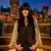 A woman with black hair standing outside a castle.