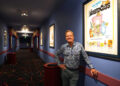 Bill Hanney, owner of Entertainment Cinemas, Theatre By The Sea and North Shore Music Theatre, is renovating the former Cape Cod Mall Regal Cinemas into Bill Hanney’s Entertainment Experience, combining movies and live theater. In this photo taken May 14, he is pictured with some of his movie poster collection that now hangs in the Hyannis theater.