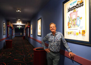 Bill Hanney, owner of Entertainment Cinemas, Theatre By The Sea and North Shore Music Theatre, is renovating the former Cape Cod Mall Regal Cinemas into Bill Hanney’s Entertainment Experience, combining movies and live theater. In this photo taken May 14, he is pictured with some of his movie poster collection that now hangs in the Hyannis theater.