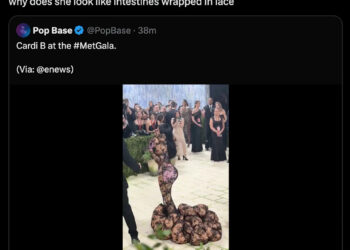 Cardi B at the Met Gala wearing a unique, lace-patterned dress with an intricate, sculptural design.