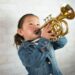 Young girl wearing a demin jacket playing the trumpet (child, musical instruments, Asian ethnicity)