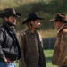 Cole Hauser, Luke Grimes and Kevin Costner in "Yellowstone." Three men in cowboy hats stand outside on a ranch.