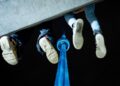 Fans of Drake dangle their feet off of a concrete structure as they gather near the CN Tower for a video projection promoting the upcoming album ICEMAN in Toronto on Friday, May 14, 2026. THE CANADIAN PRESS/Arlyn McAdorey