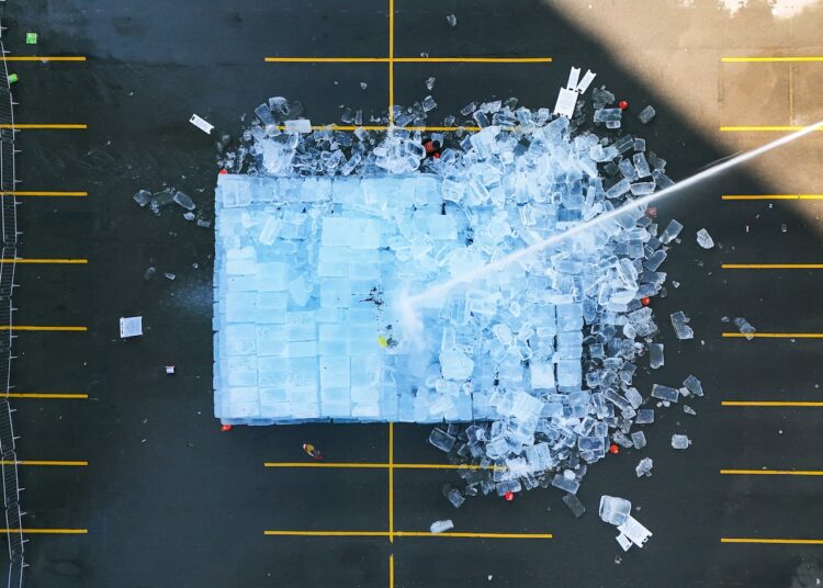 Overhead as water is sprayed on large installatin of ice blocks