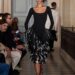 Model walking on runway in a black gown with layered ruffles