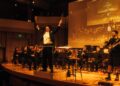 Eric André conducting on stage alongside Prateek Rajagopal, who collaborated with him on his debut classical album.