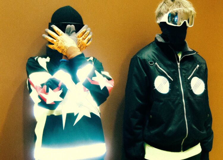 Image may contain Clothing Coat Jacket Costume Person Adult Hood Pants Hoodie Knitwear Sweater and Sweatshirt