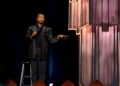 Comedian standing on stage with a mic