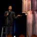 Comedian standing on stage with a mic